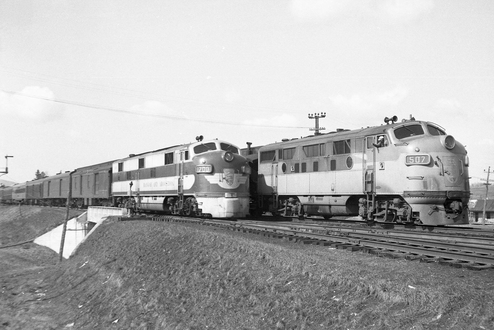 Bangor & Aroostook engineer on train #21 with F3 #507 waves to the engineer on train #1 with E7 #700 at Oakfield, Maine on April 29, 1950.