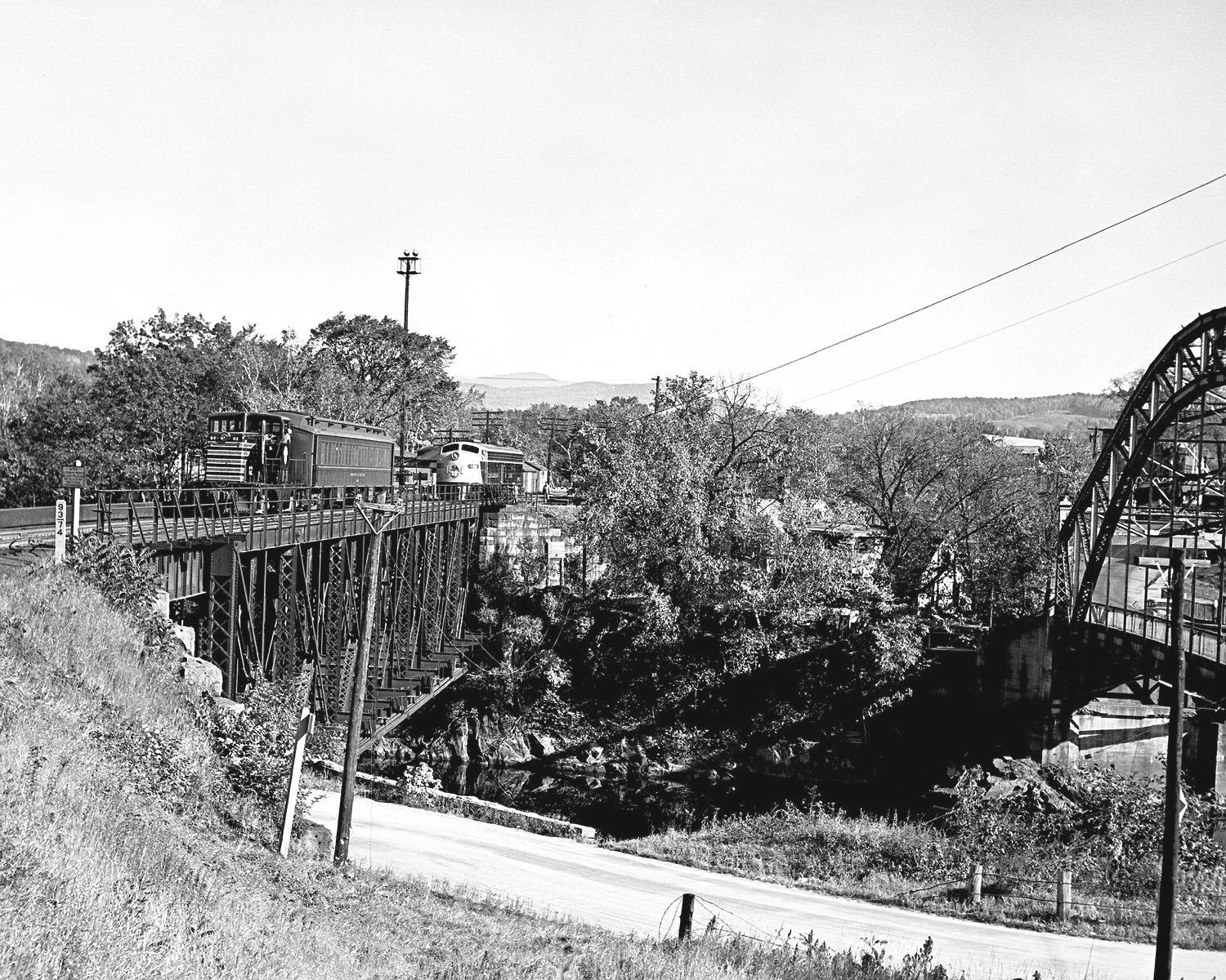 Boston and Maine 44T 112 switching out a passenger car at Wells River, VT in 1953. A CPR E8 waits on  the other track over in Woodsville, NH. (8x10)