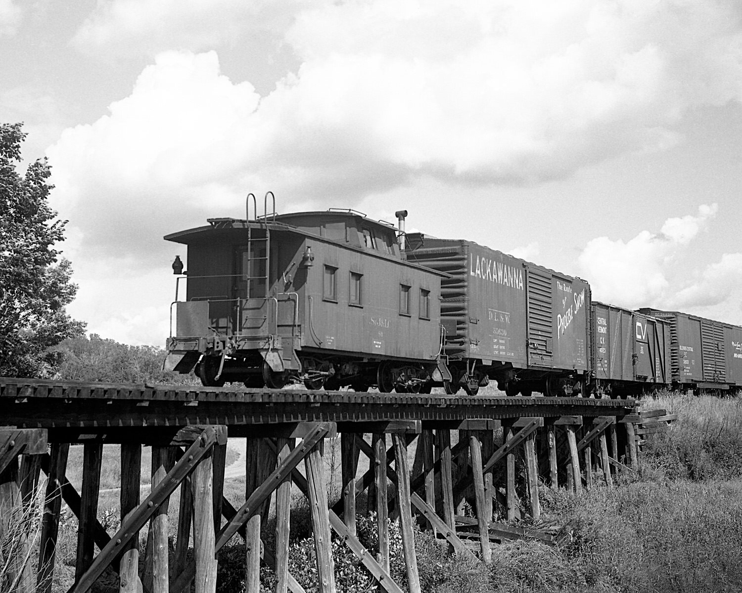 St. Johnsbury & Lamoille County Railroad caboose #80 pulls up the markers on train #74 near East Fairfield, Vermont. Mid to late 1960's. (8x10)