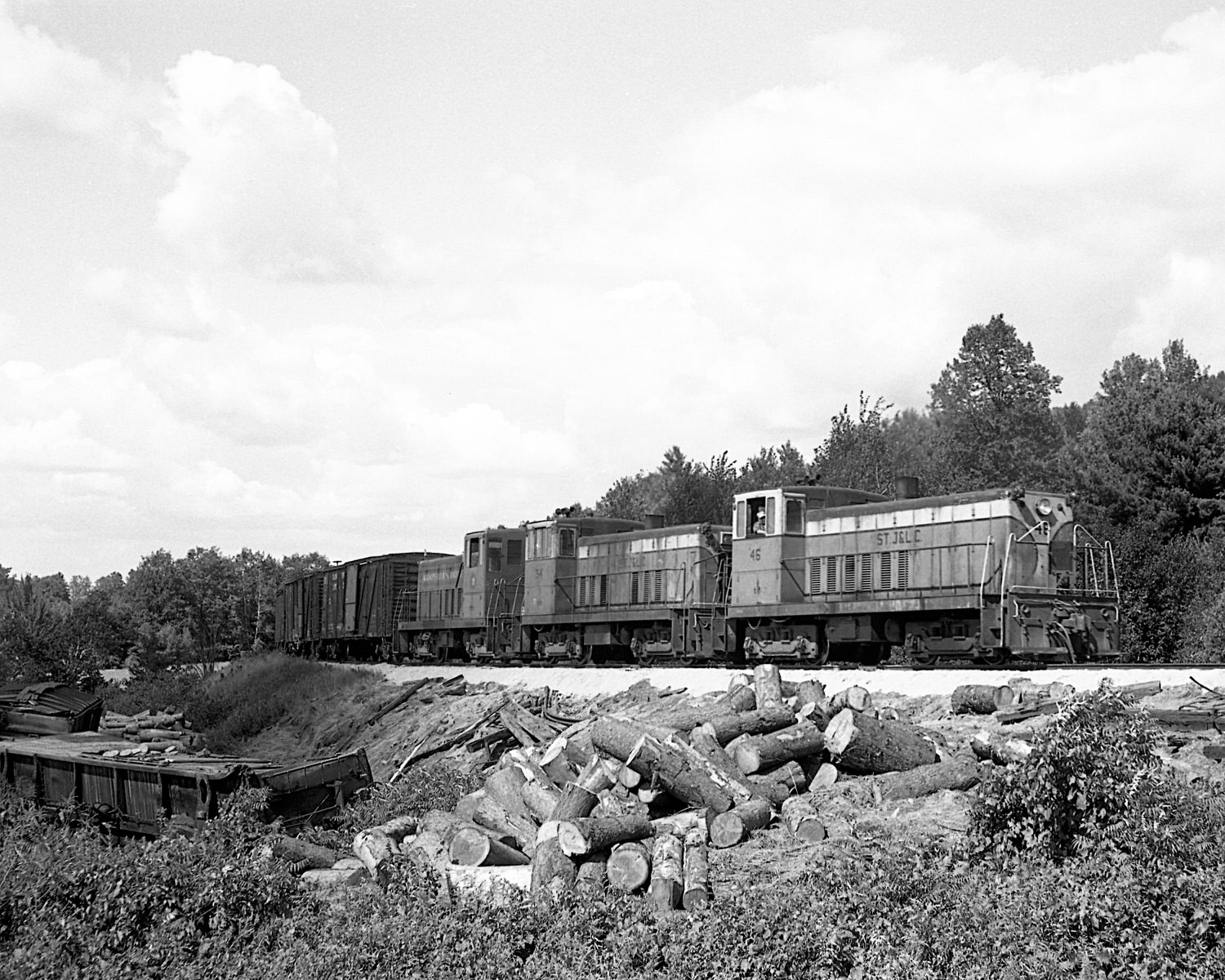 St. Johnsbury & Lamoille County Railroad 70 tonners #46, 54 & Montpelier & Barre #19 pass a derailment site during the late 1960's. Location was not recorded. (8x10)